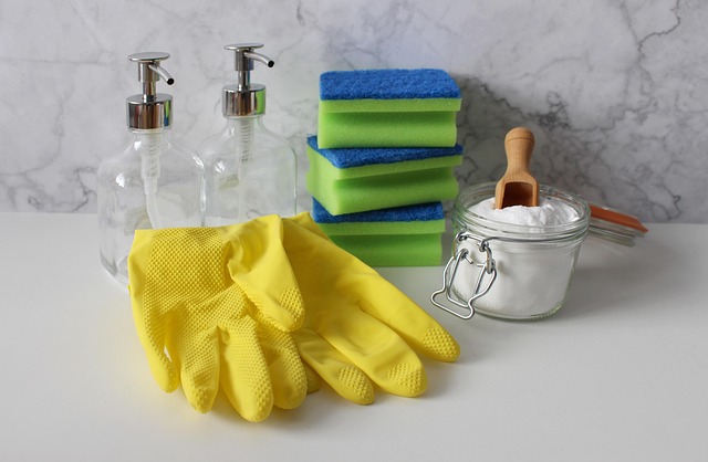 Yellow%20cleaning%20gloves%20holding%20a%20blue%20sponge%20against%20a%20glass%20surface Yellow cleaning gloves holding a blue sponge against a glass surface